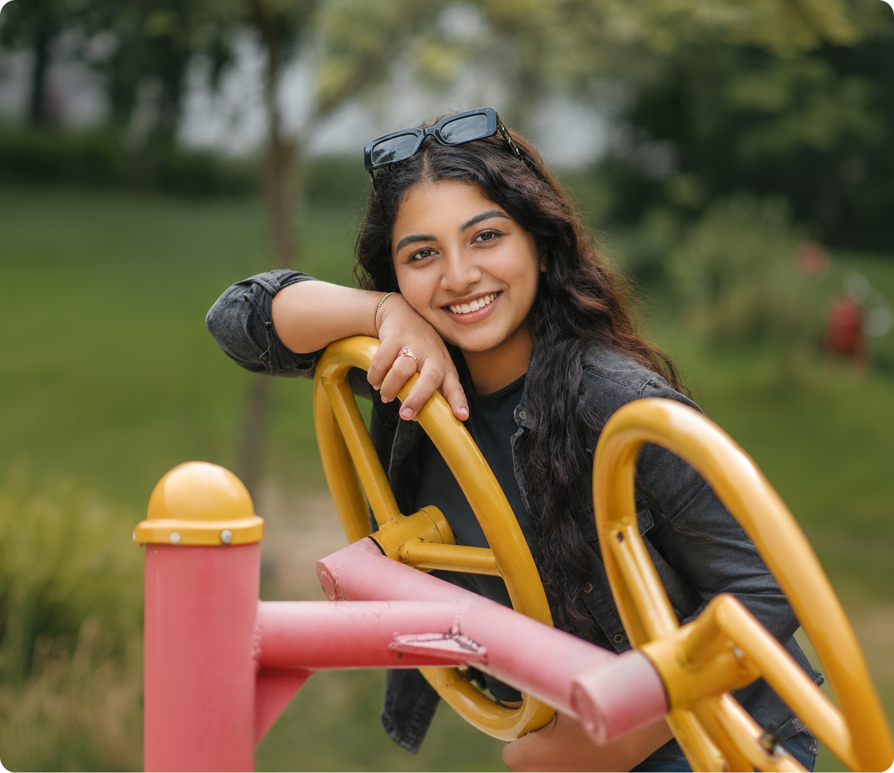 A young woman smiling outdoors in a park